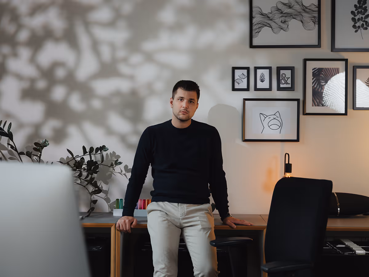 Marcel Speckmann, der Gründer und Geschäftsführer von Speckmann Webdesign GmbH lehnt an einer Tisch und schaut in die Kamera