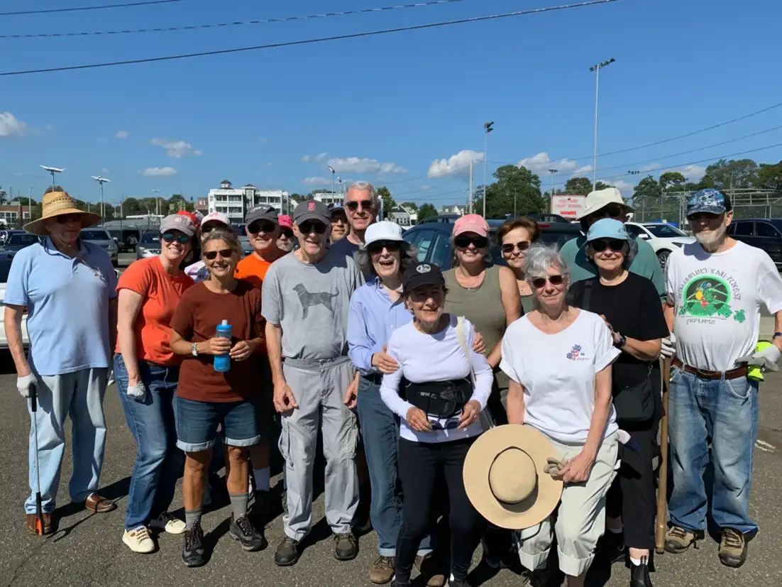 Group of volunteers smiling outdoors after a successful coastal cleanup event, contributing to the "Reverse Tashlich" initiative to protect marine life.
