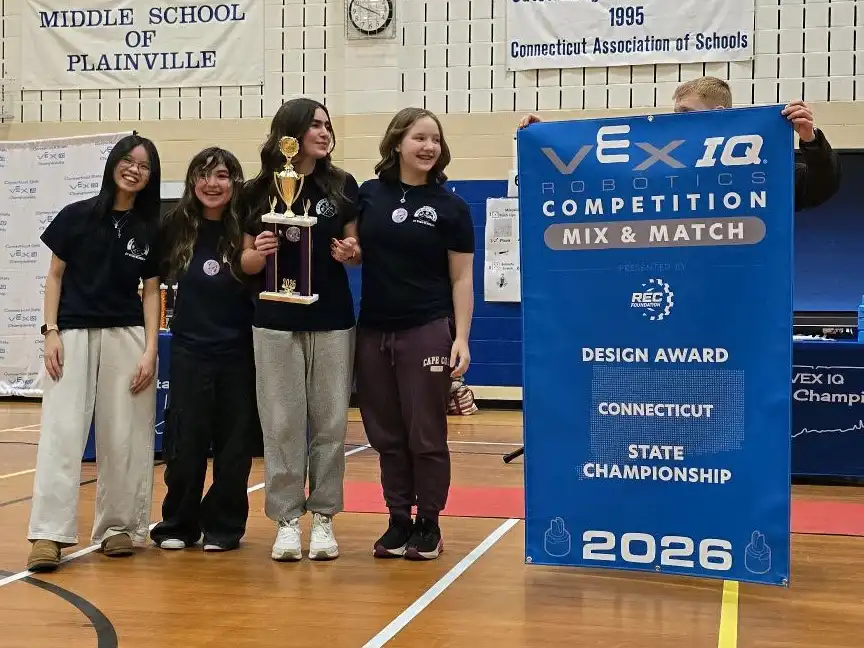 Four CT STEM Academy students smile with a trophy and banner after winning the Design Award at the 2026 VEX IQ Robotics Connecticut State Championship.