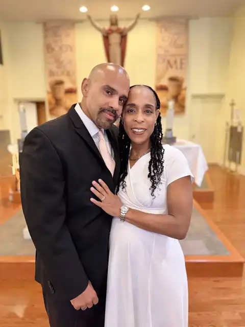 A close-up portrait of Drs. Rey and Dennie Ramos embracing inside the church during their 25th wedding anniversary celebration.