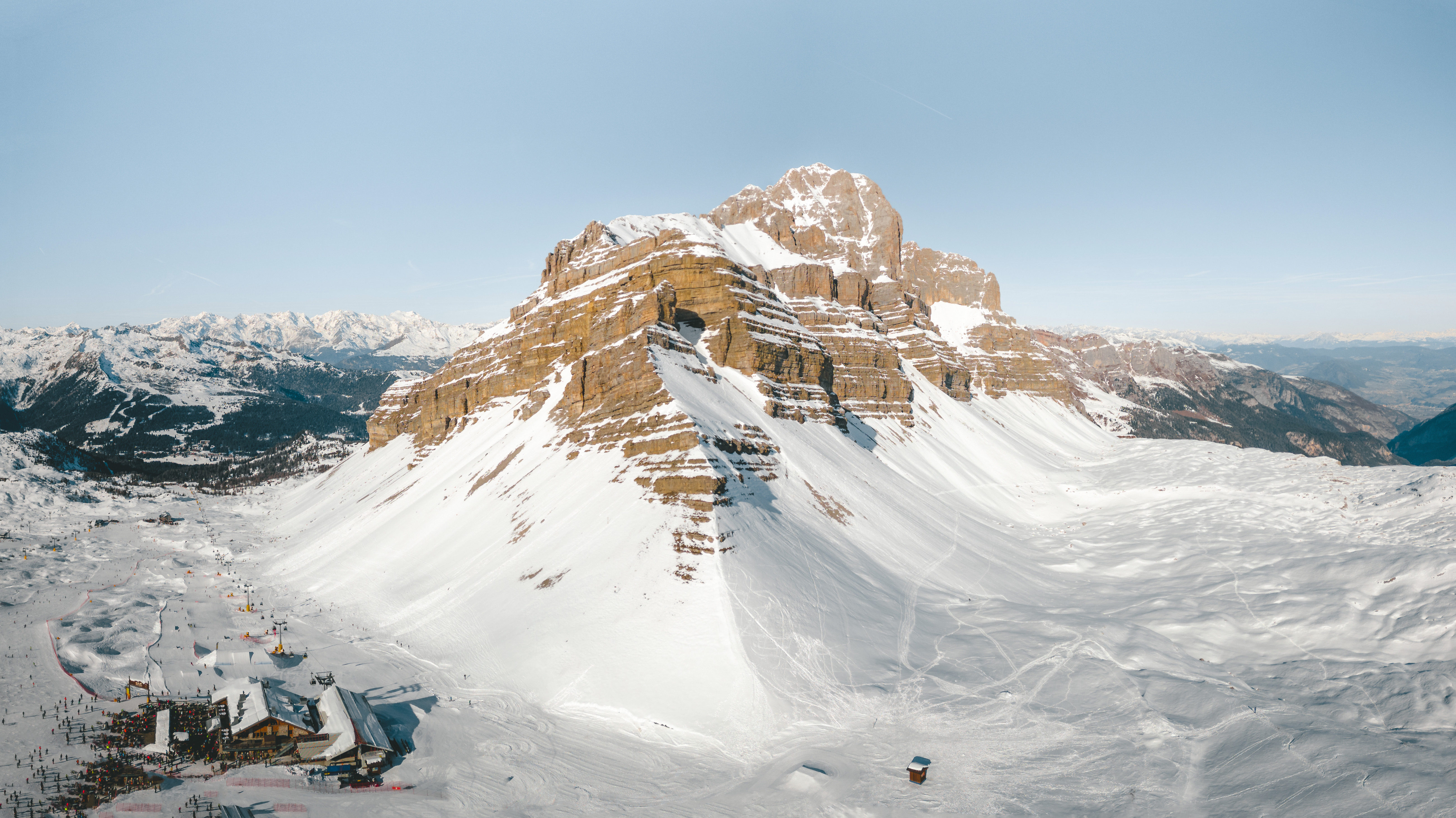 Photo of Bird's eye view shot of a multilayered mountain range covered in snow, centrally composed 