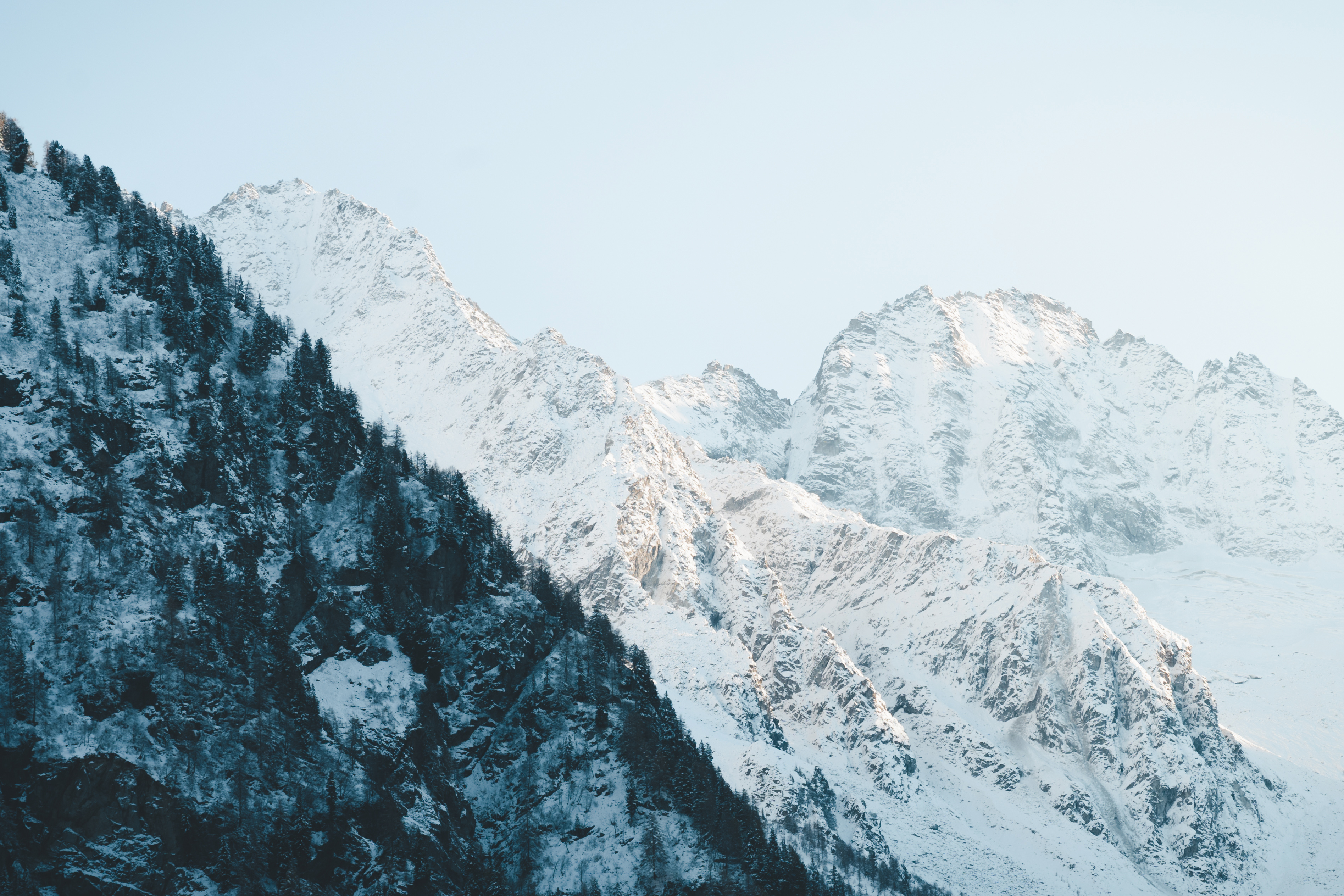 Photo of Mountains overlaying covered in snow, close up with blue tones