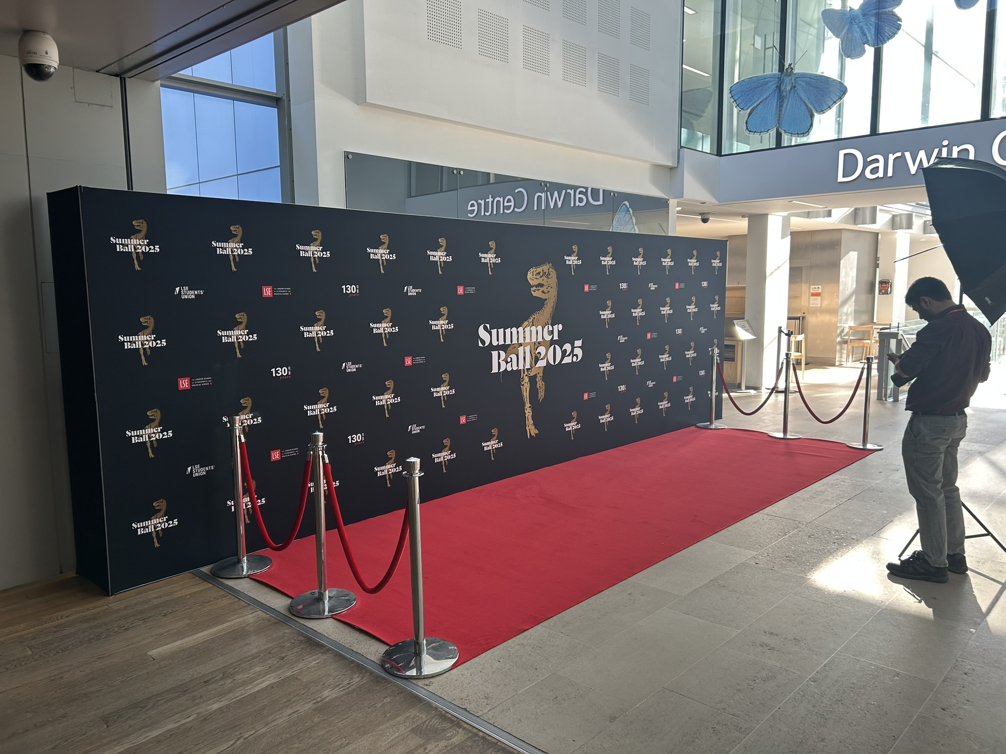 Red carpet and rope barriers with a 7.2m wide step and repeat wall at the natural history museum london with phorographer and lights