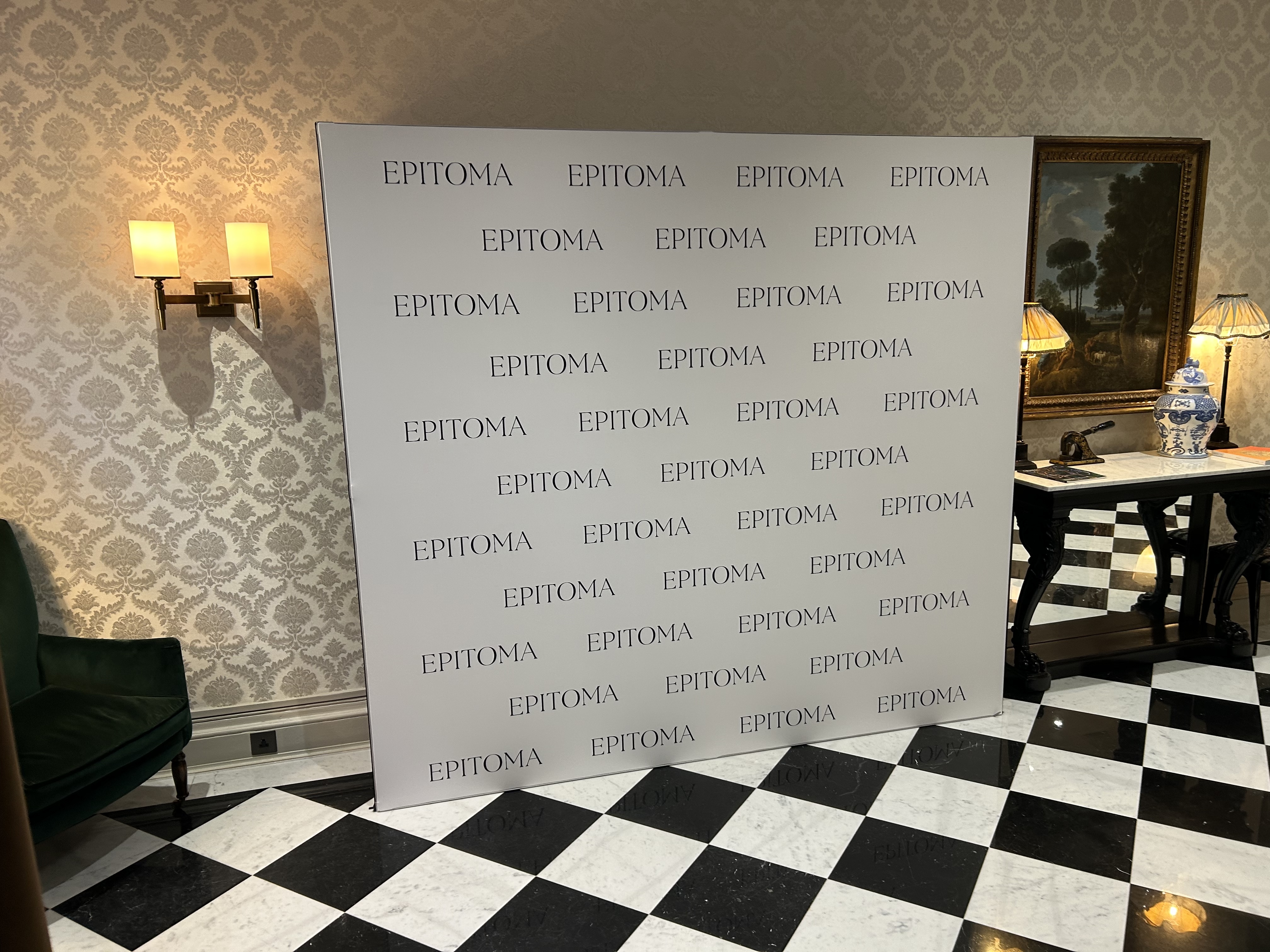 South kensington hotel event backdrop. White background black logos