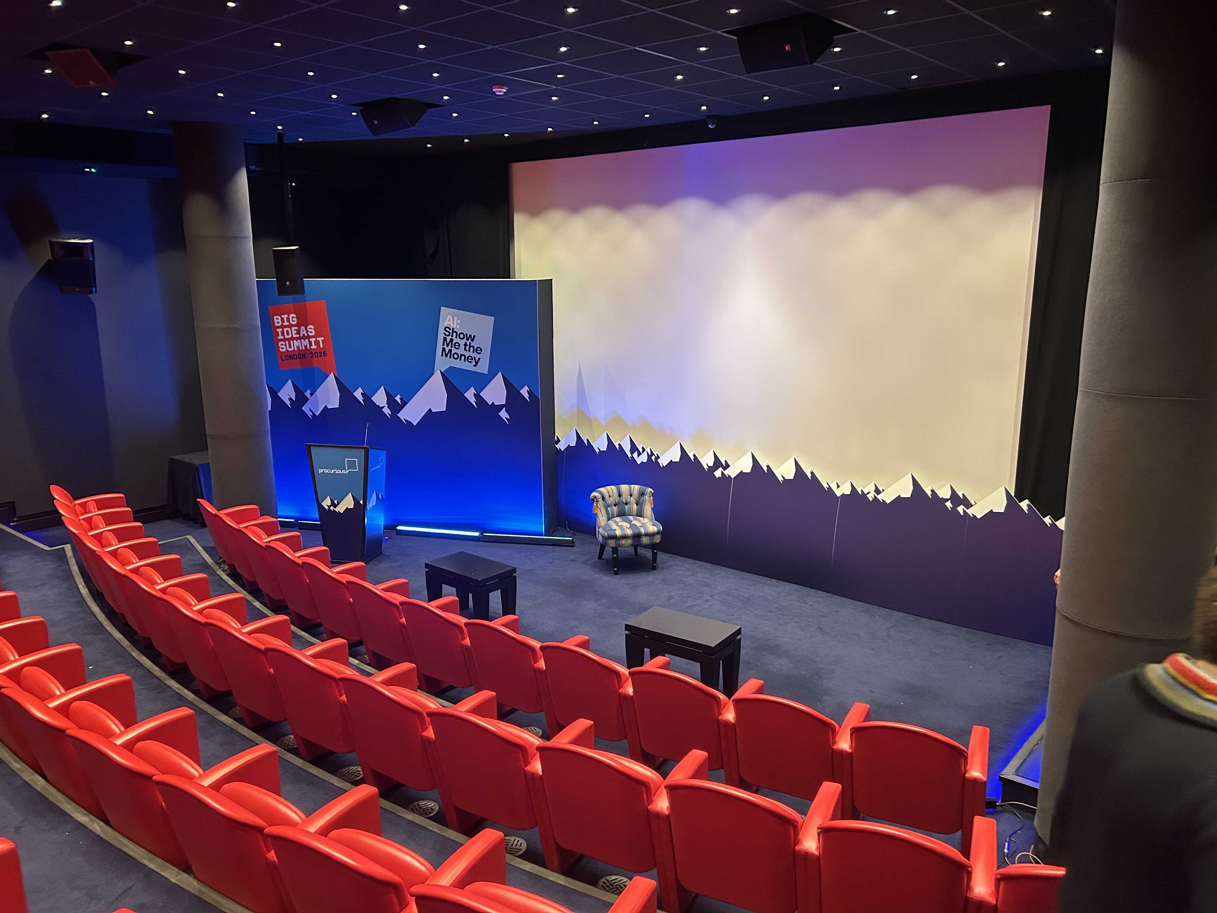 Keynote speaker backdrop in front of a presentation screen.