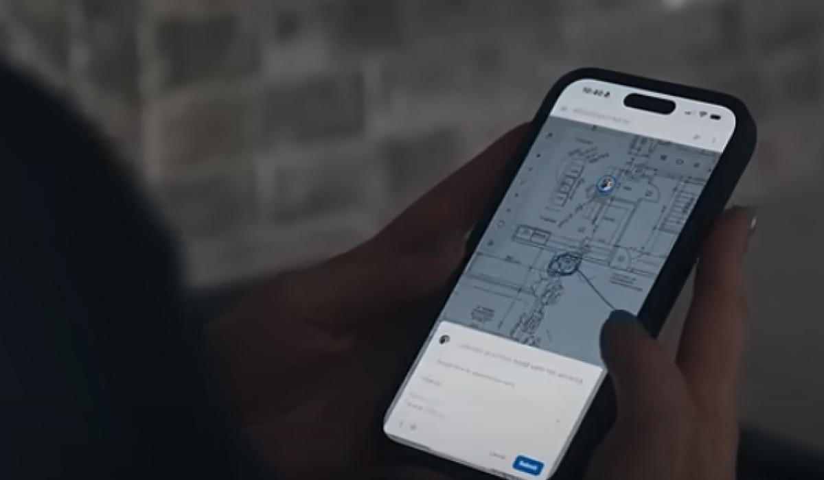 A person viewing a digital floor plan with collaborative comments on a smartphone, illustrating mobile access to construction project data on the go with the Digs platform.