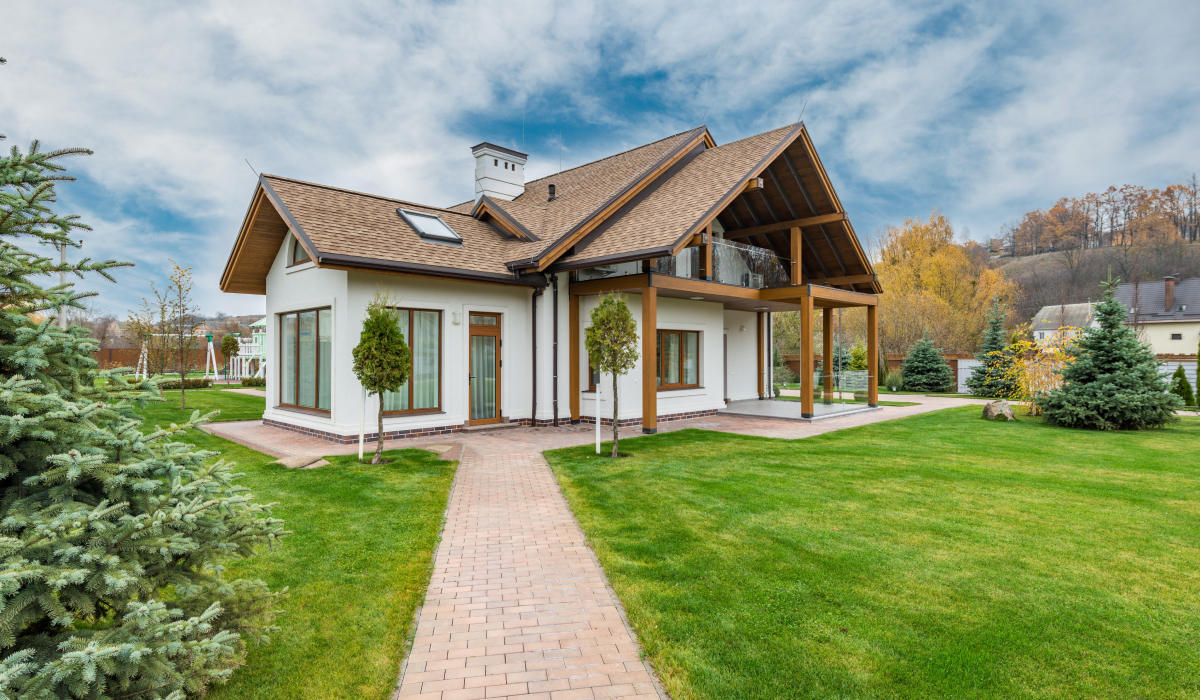 White stucco home with natural wood beam accents and gable roof