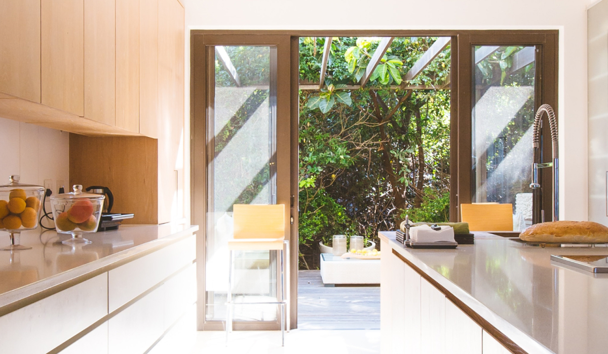 Bright kitchen with glass sliding doors opening to a sunlit garden