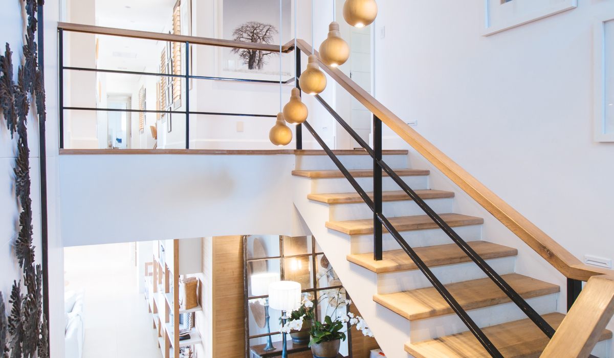 Sunlit staircase with pendant lights and an open floor plan connecting two levels