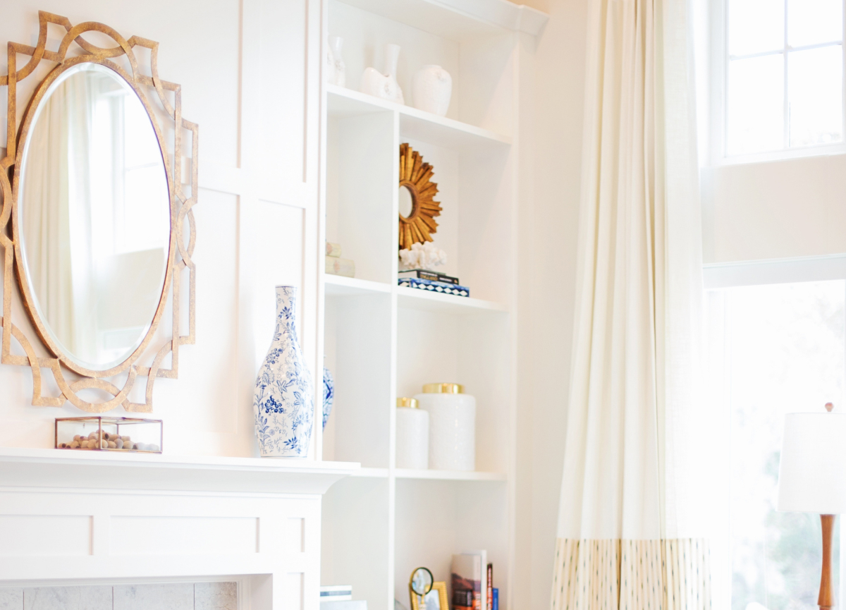 Sunlit living room corner with floor-to-ceiling window and light-colored decor