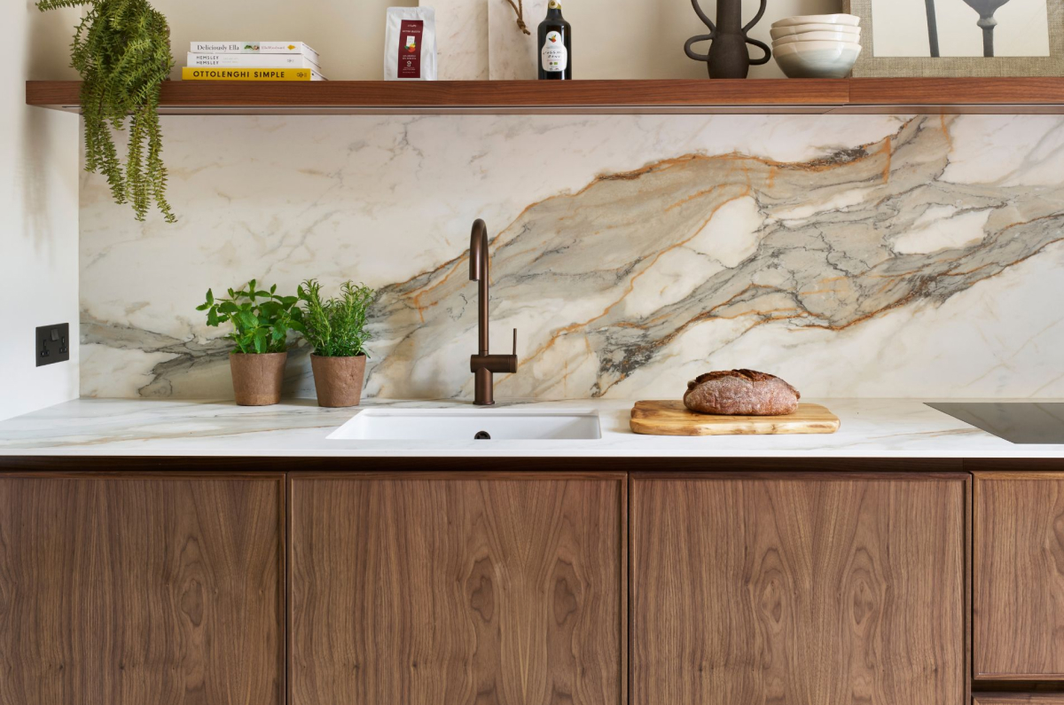 Walnut cabinets paired with a dramatic veined marble backsplash and bronze faucet