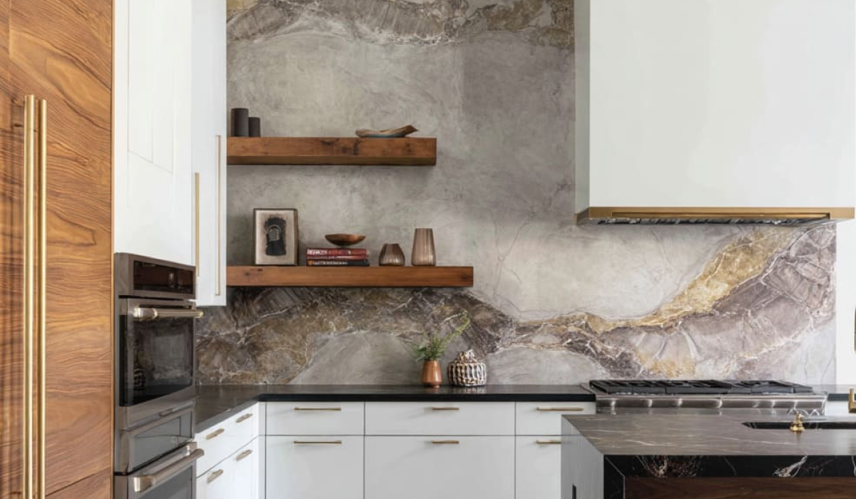 White kitchen with a bold gold-veined stone slab backsplash and walnut cabinet accents