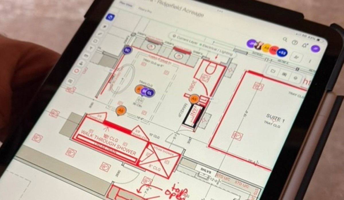 iPad displaying redlined electrical and lighting floor plan markups for a builder to review on-site