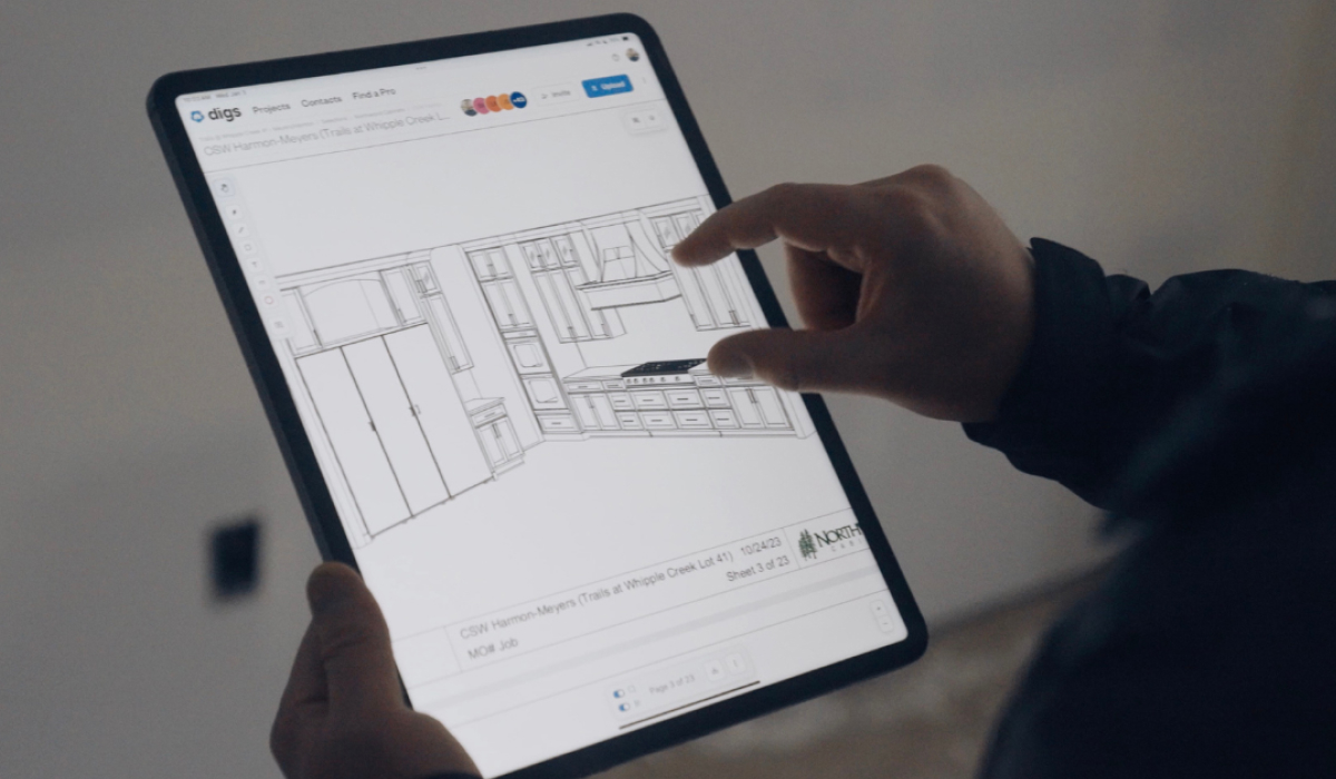 Homebuilder reviewing kitchen cabinet drawings on a tablet in Digs, with project documents stored in one place.