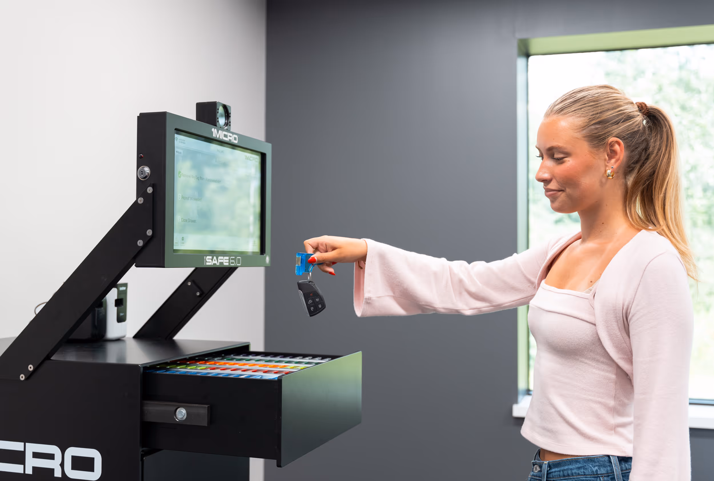 A woman reaching to put keys back in the iSafe Pro 6.0., image
