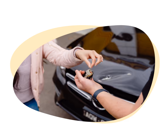 Round image of a woman handing a mechanic the keys to her car.