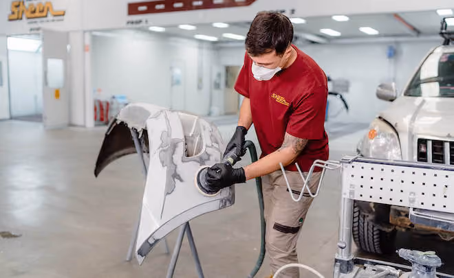Technician at work in the Sheen workshop, detailing the hands-on process of vehicle repair.
