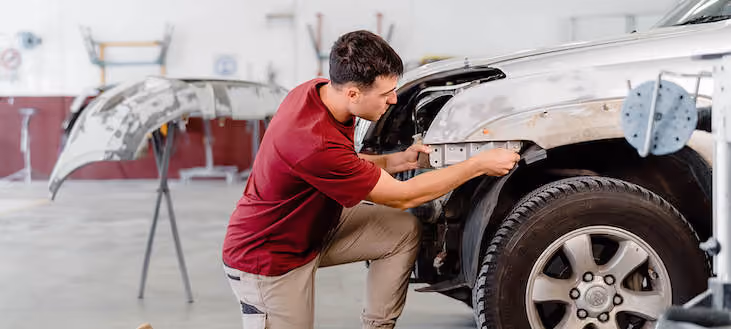 Workshop image showing technicians at work on vehicle repairs in a well-equipped garage.