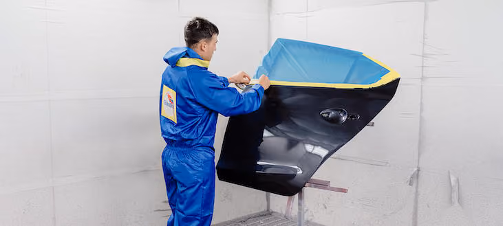 Dynamic workshop image showing Sheen Panel staff engaged in vehicle repair tasks.