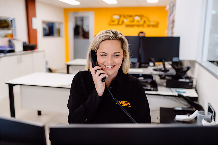 Blonde woman working at Sheen takes a phone call in the office.