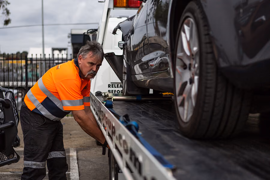 Image capturing a Sheen towing service in action, with a tow truck and operator assisting a stranded vehicle.