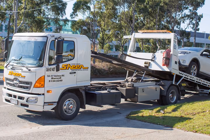 A towing service in action, with a tow truck assisting a disabled vehicle.