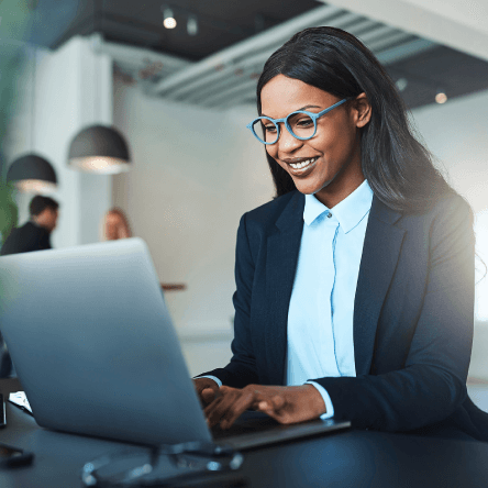 A woman smiling at a computer, meant to represent that she has received an excellent sales gift for prospects. 