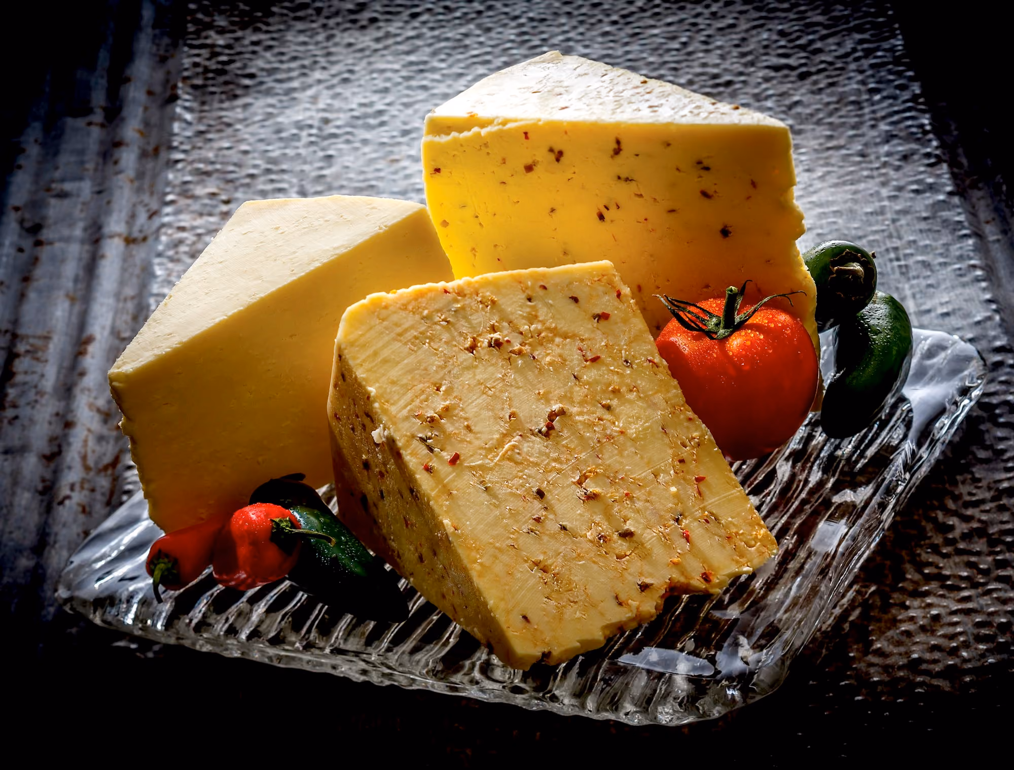 Three wedges of cheese displayed with fresh salsa ingredients