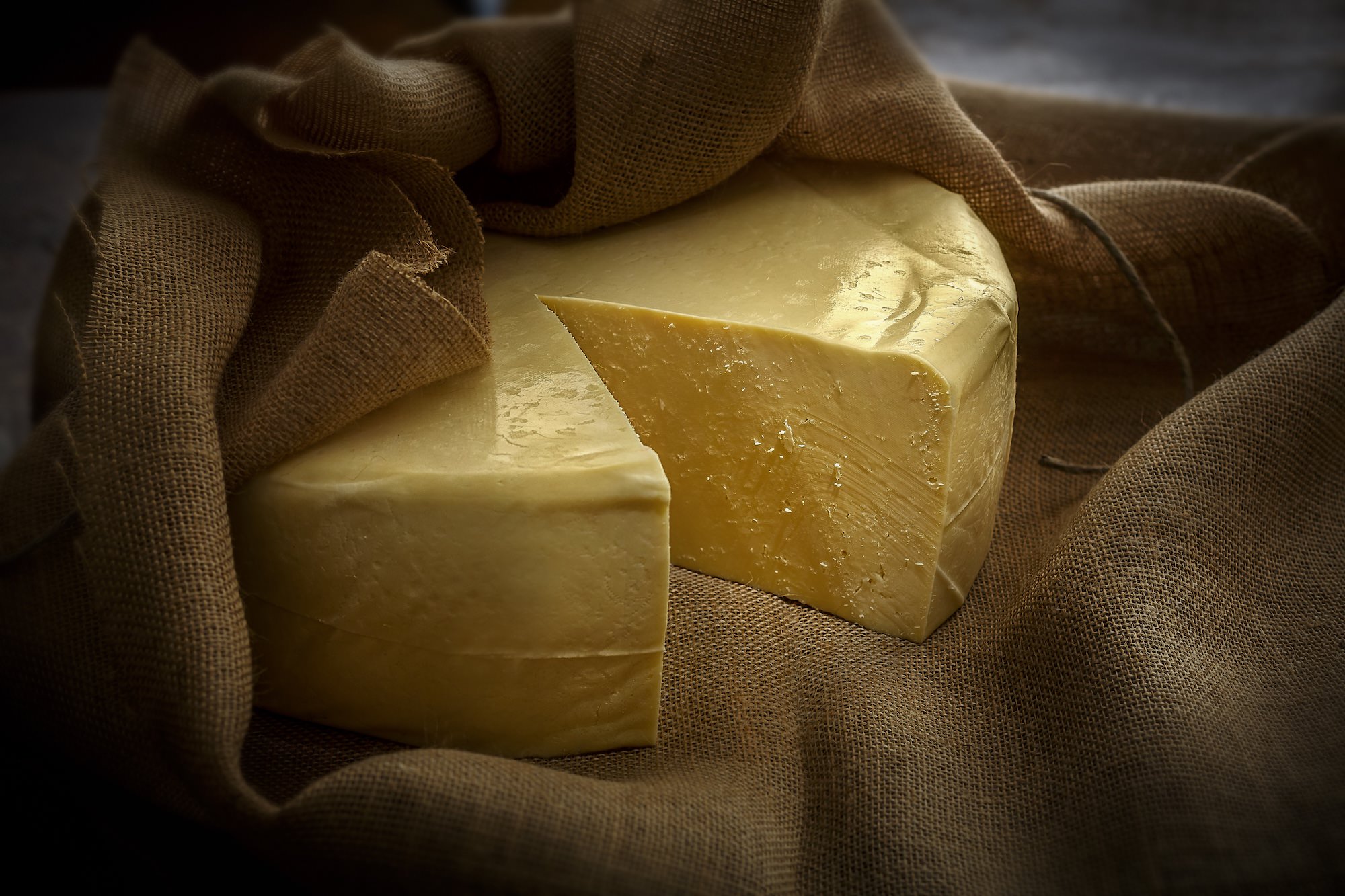 A wheel of Queso Fresco cheese wrapped in brown linen. 