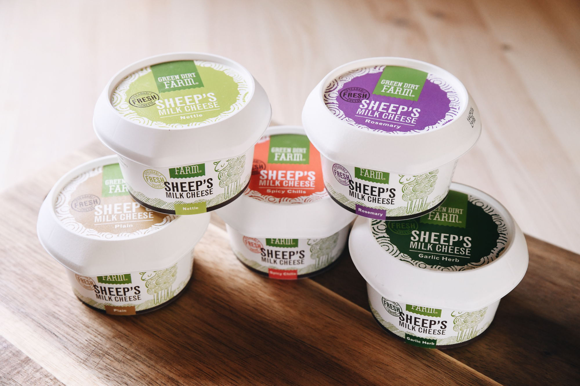 An image of all five flavors of Green Dirt Farm's Fresh cheese cups stacked