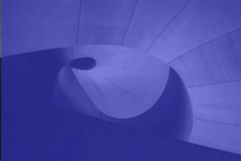 Abstract spiral staircase with smooth concrete surfaces viewed from below.