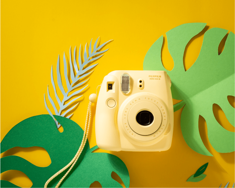 Polaroid camera against yellow background