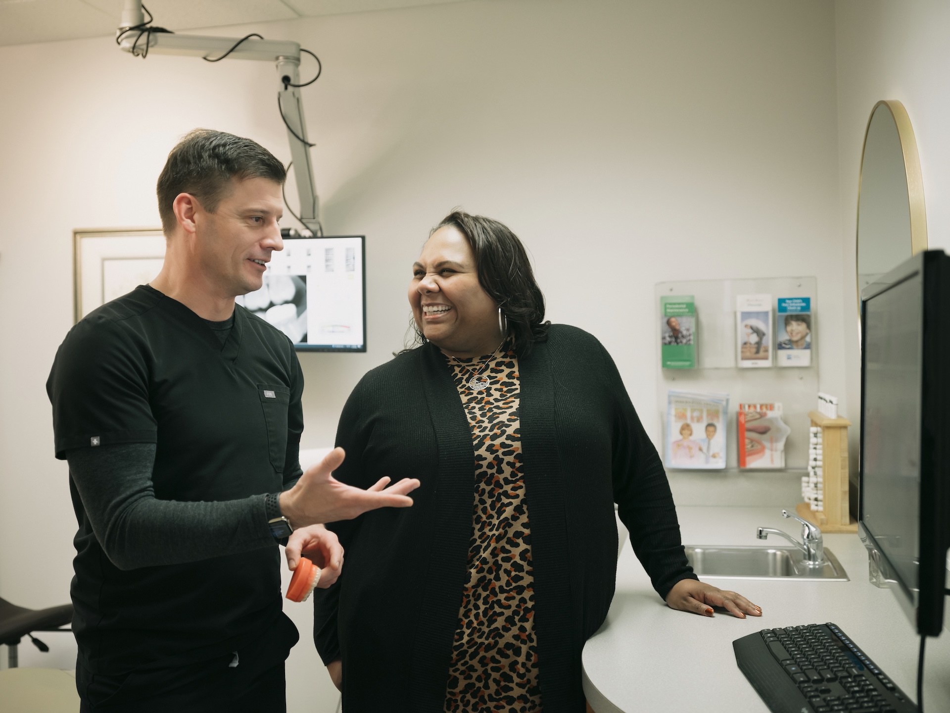 Dentist discussing treatment options with a patient in a dental exam room at Decker Dental.