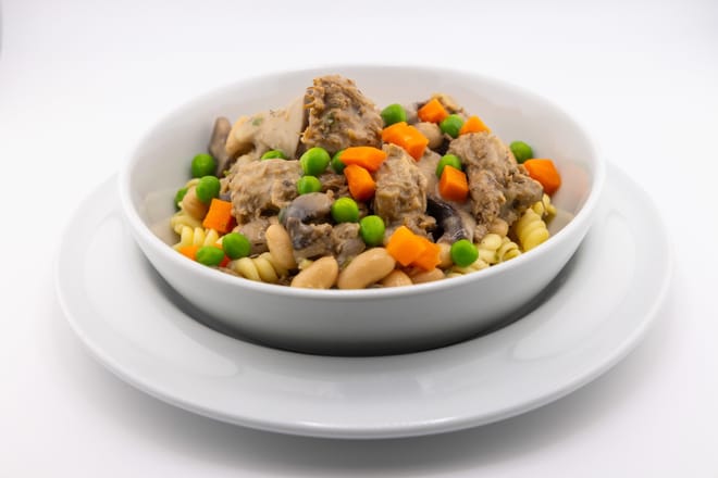 Vegetables in a white bowl against a white background.