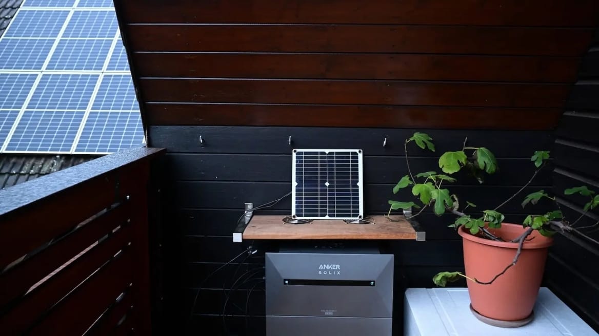 Solar panels on a balcony with a roof. A potted plant is also on the balcony.