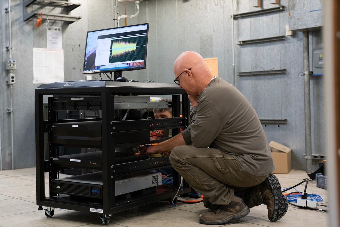 A Prisma Photonics employee installs equipment in a substation operated by Minnesota electric cooperative Great River Energy