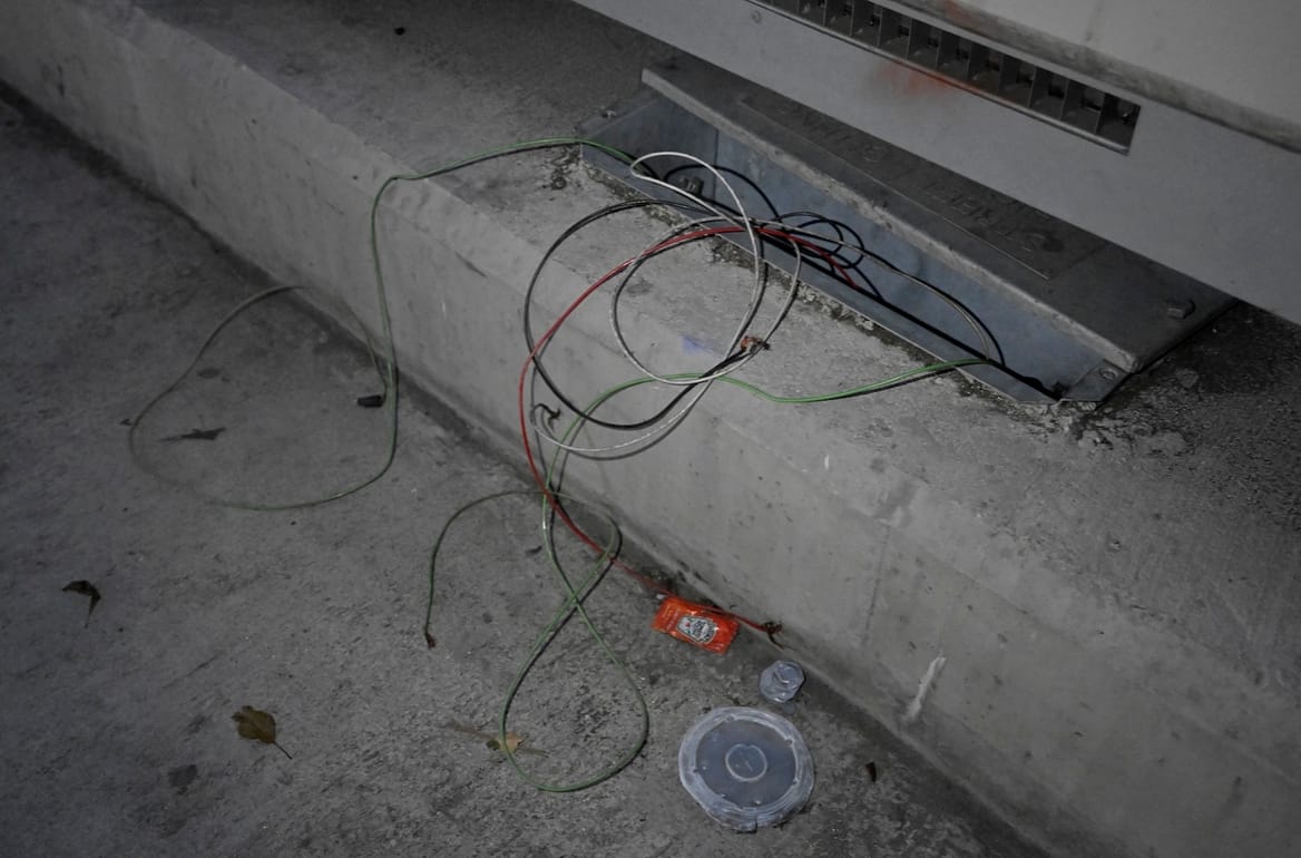 Wires pulled out of a box embedded in a sidewalk