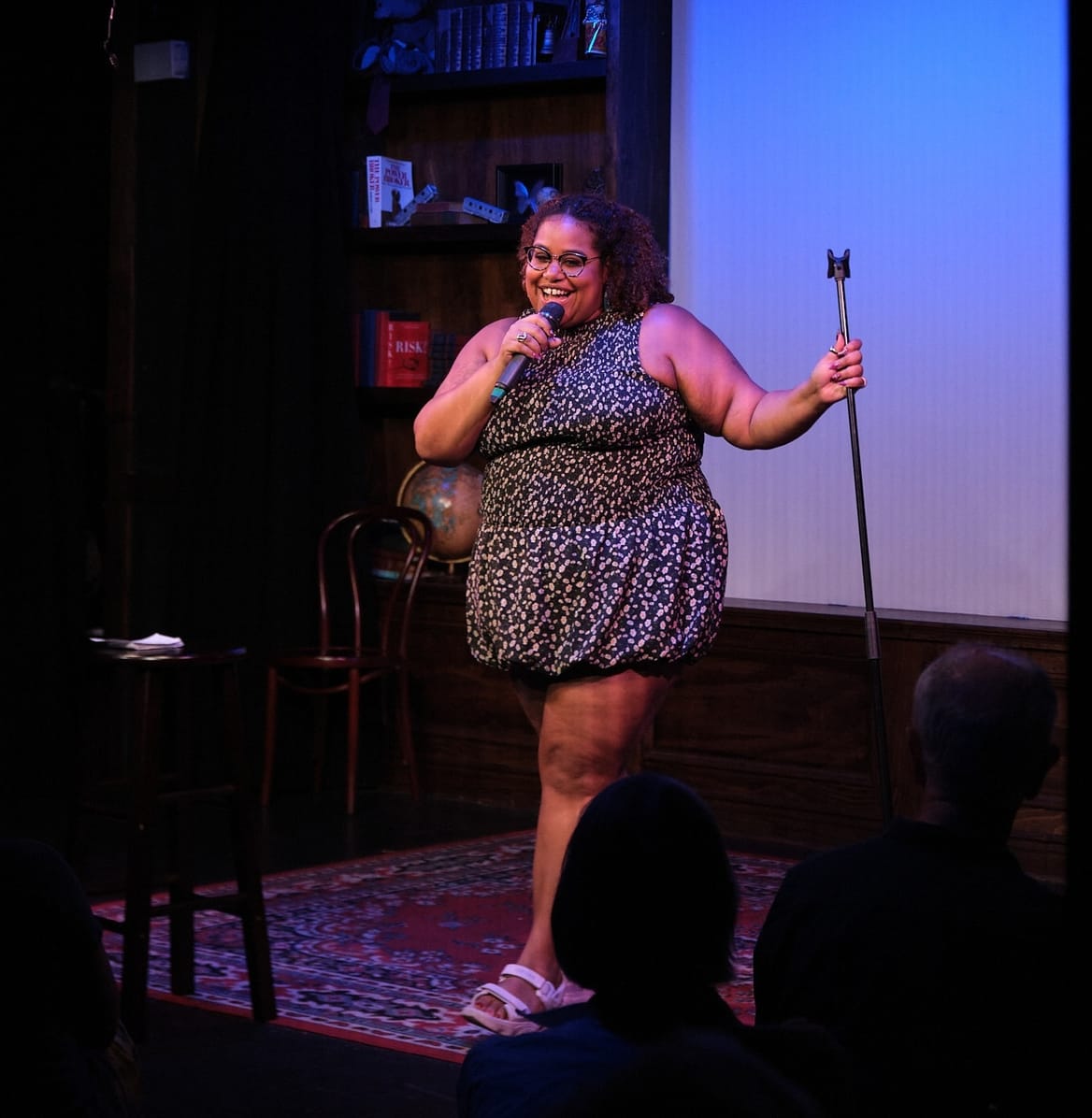 A person holds a mic on a stage