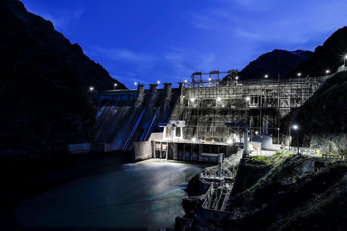 Equipment and a dam on a river at night time