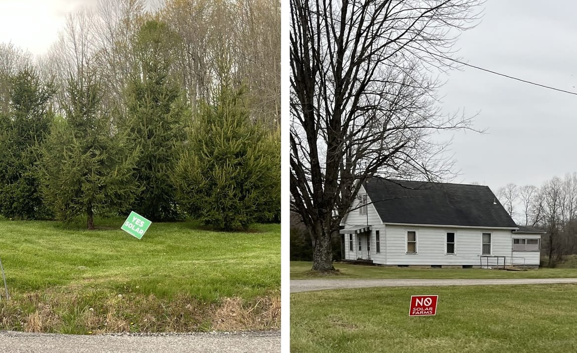a green "yes solar" sign in front of trees and a red "no solar farms" sign in front of a farmhouse