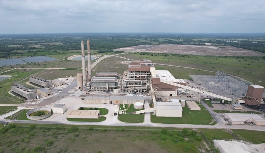 Coal plant site shot from above, with grass and trees to the horizon