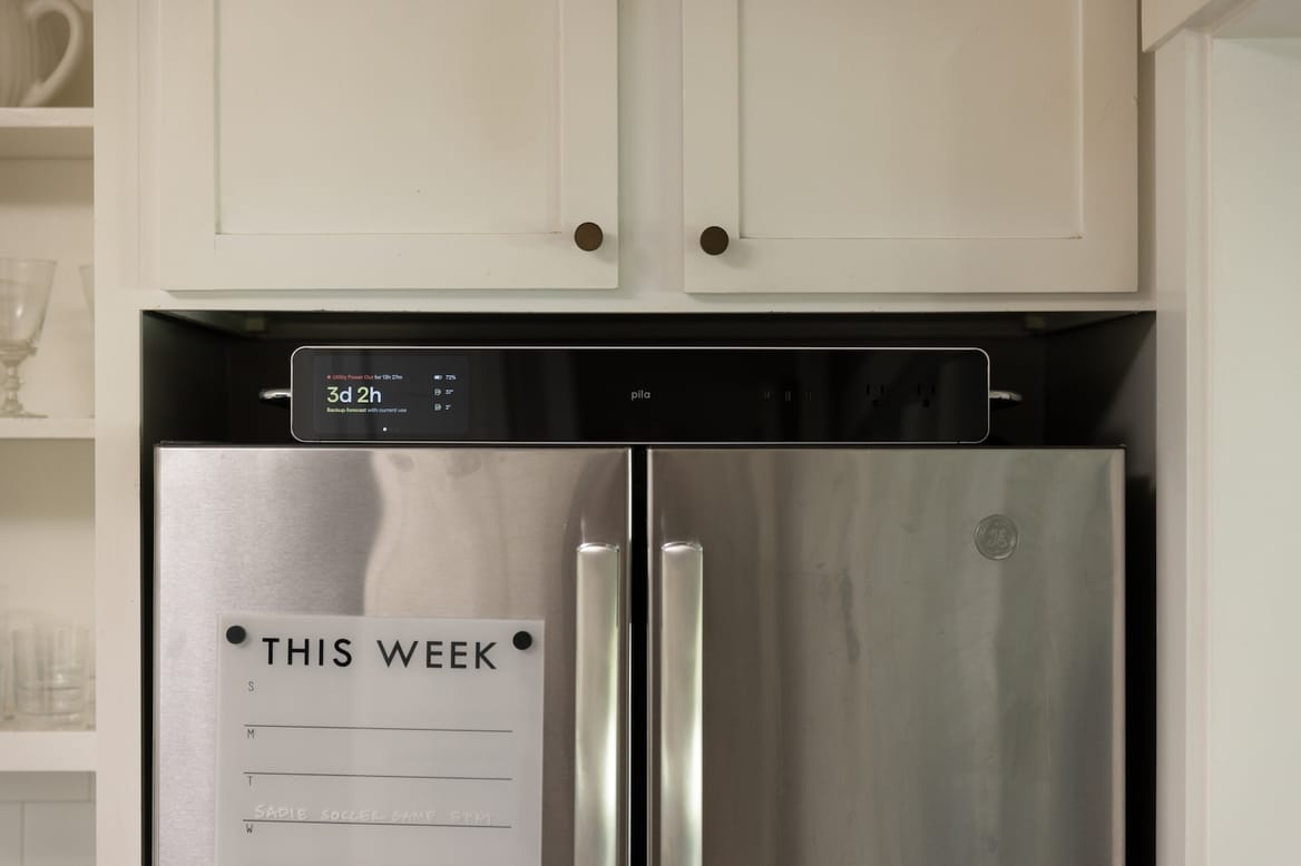 suitcase-size battery device atop chrome double-door fridge