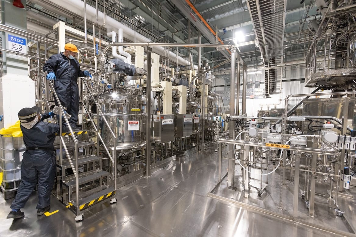 Two workers inside a gleaming factory