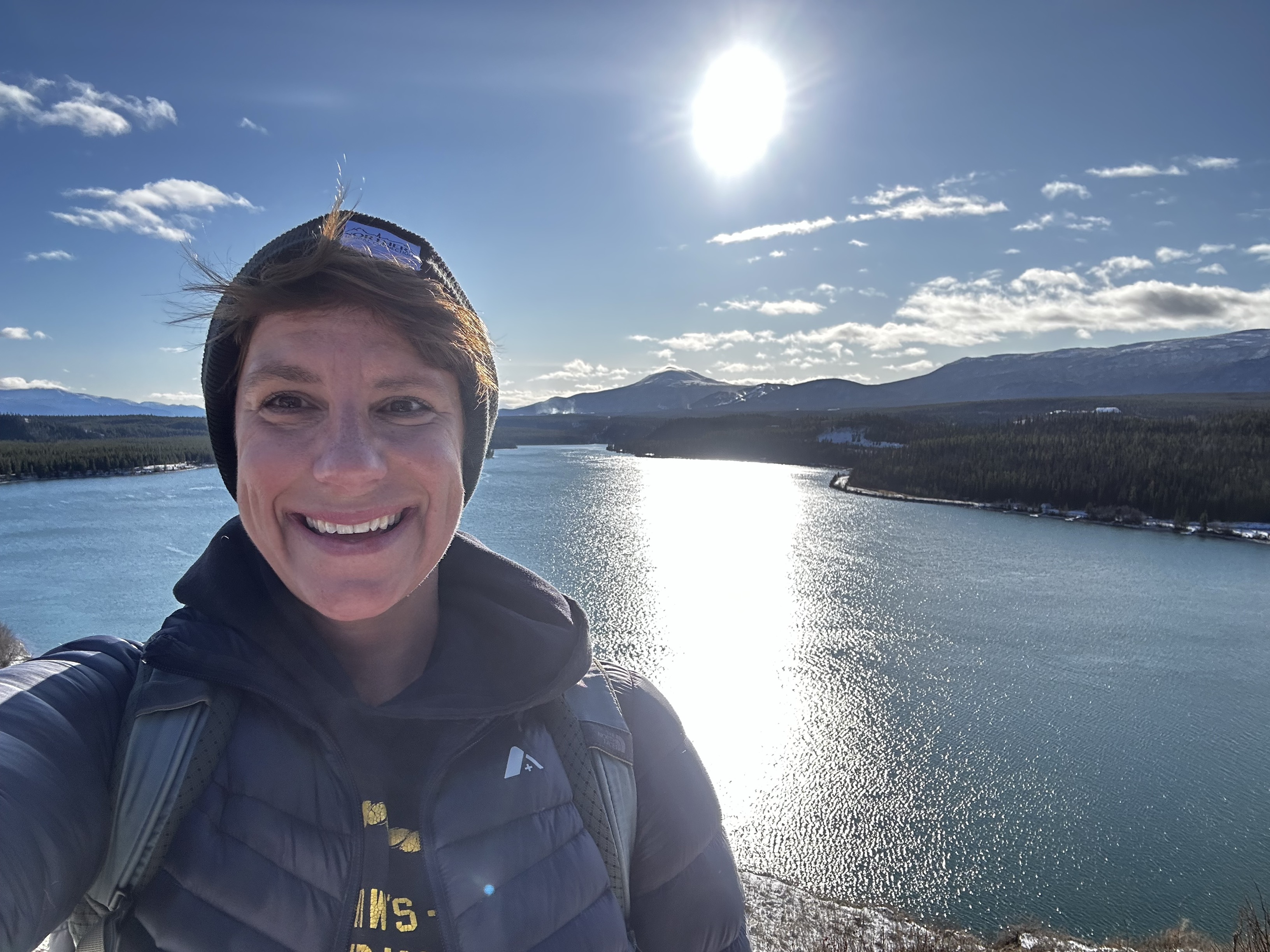 Smiling woman beside a lake on a sunny day