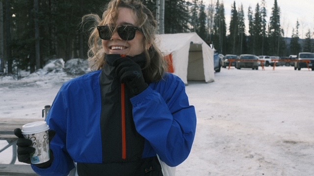 Travel nurse in a blue jacket and toque standing in the snow
