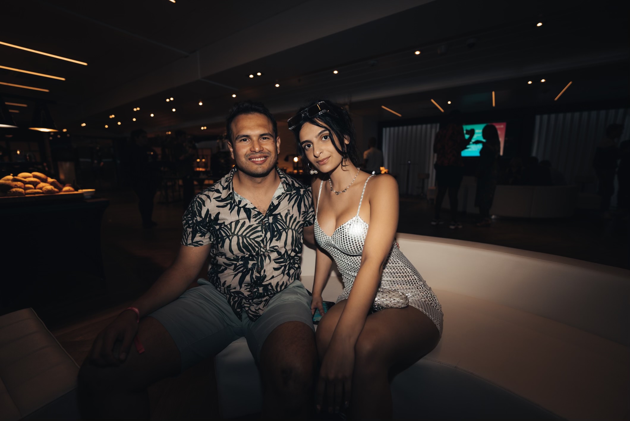 An Image of a man and a woman posing during a celebration at night