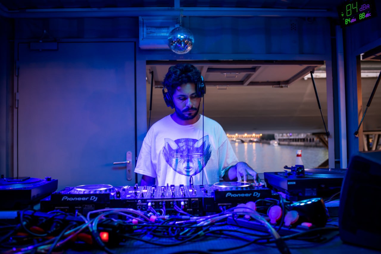 a man wearing head phones in a dj booth playing music in a dj booth