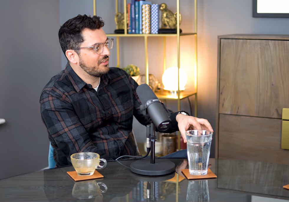 A man sitting at a table with a cup of coffee.