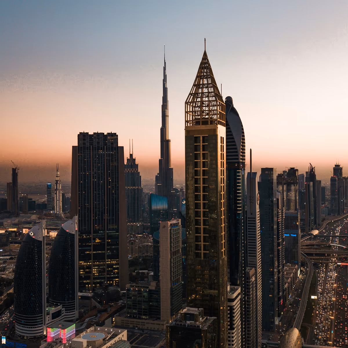 A cityscape with a large building and a tall tower.