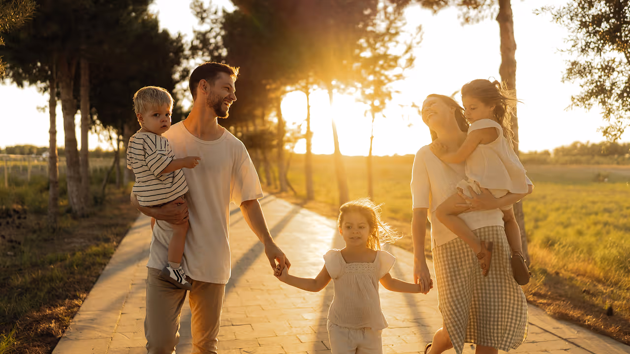 A family of six walking together on a brick path.